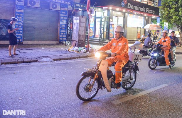 Staff members in Hanoi Electricity Department patrol on a local street to call on residents to save power.