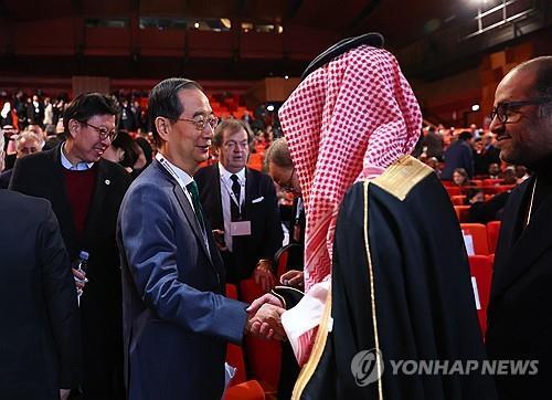 South Korean Prime Minister Han Duck-soo shakes hands with a Saudi official after the final presentation for South Korea's bid to host the 2030 World Expo at the 173rd general assembly of the Bureau International des Expositions held at the Palais des Congres in Paris before its members vote for the host city on Nov. 28, 2023. (Yonhap) 