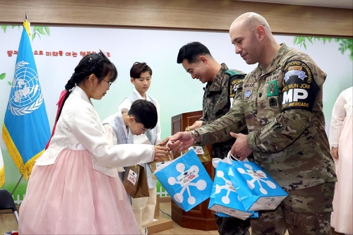 Students of Daeseongdong Elementary School, the only school inside of the Demilitarized Zone separating the two Koreas, receive gifts from leaders of the United Nations Command Security Battalion during a graduation ceremony on Jan. 5, 2024, in this photo provided by the Korean National Defense Daily Newspaper. (PHOTO NOT FOR SALE) (Yonhap) 